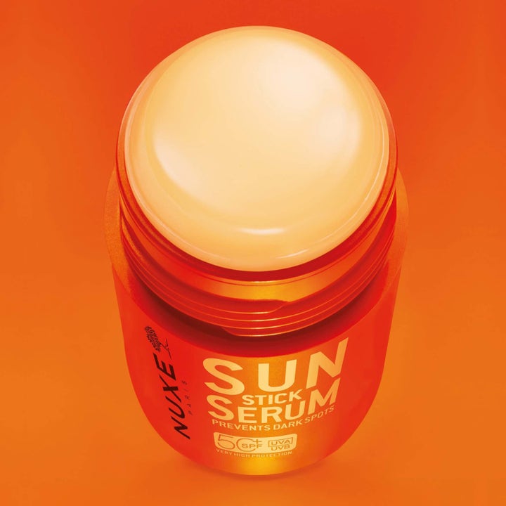 Nuxe Sun Stick Serum 25 g solstift med SPF 50+ som forebygger mørke flekker og viser den faste teksturen i oransje hylse.