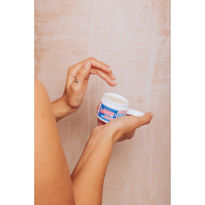 Egyptian Magic All Purpose Skin Cream 59 ml gir fuktighet i en hvit krukke som holdes åpen av en person.
