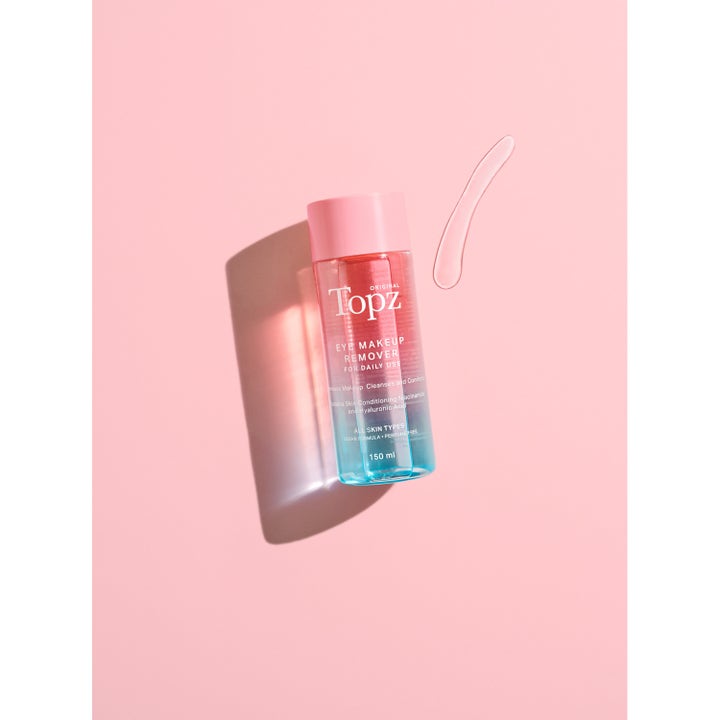 Topz Daily Eye Makeup Remover 150 ml øyesminkefjerner med niacinamide i rosa og blå flaske med flytende geltekstur.