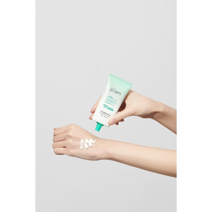 Make Prem No Sebum Sun Cream 50 ml i tube som påføres håndrygg med en silkemyk hvit tekstur.