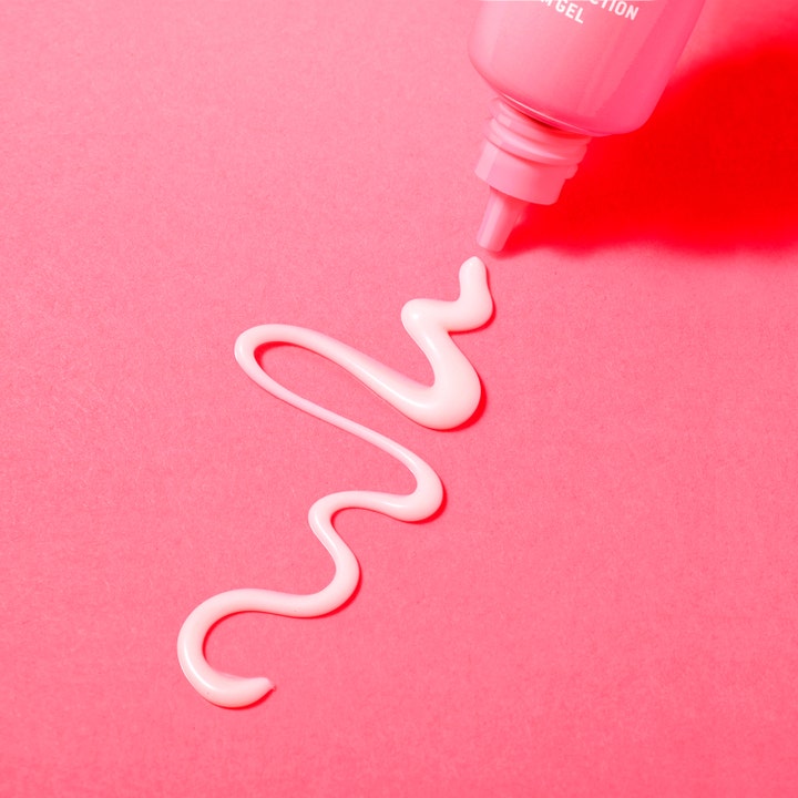 Nuxe Creme Prodigieuse Boost 15 ml øyekrem med lett gelkonsistens i en bølgete linje på rosa bakgrunn