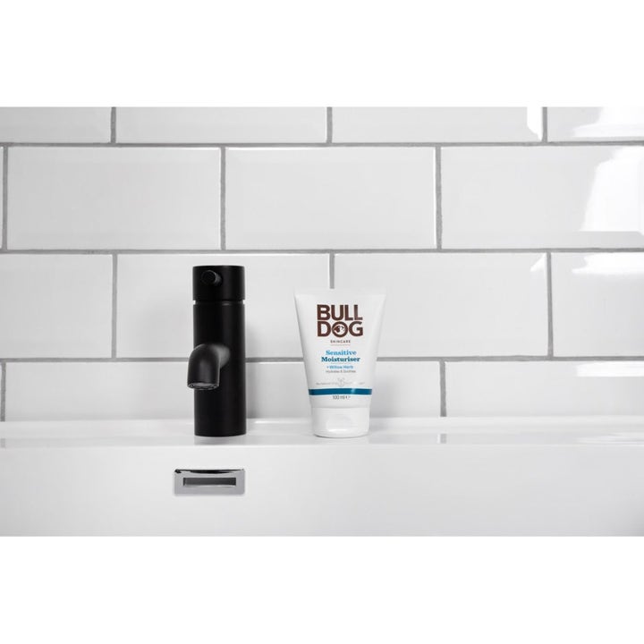 Bulldog Smooth Shave Prep 225 ml eksfoliering står i hvit tube ved en moderne sort kran for skånsom rakning.