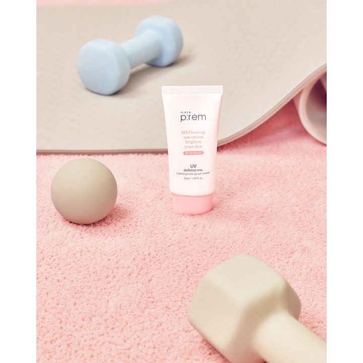 Make Prem Calming Tone Up Sun Screen 50 ml beroligende solkrem SPF 50 i hvit tube ved siden av treningsutstyr.