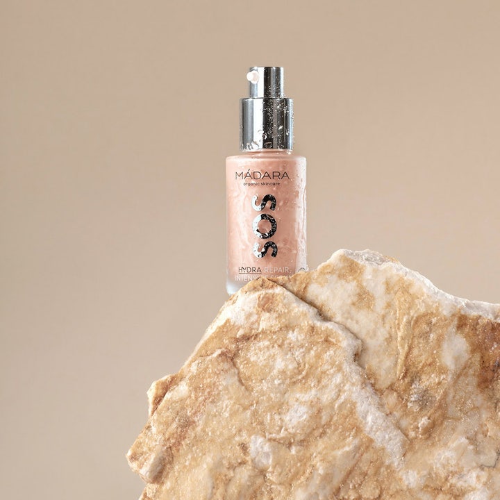 MÁDARA SOS Hydra Repair Intensive Serum 30 ml fuktighetsgivende serum i glassflaske med vanndråper på en stein