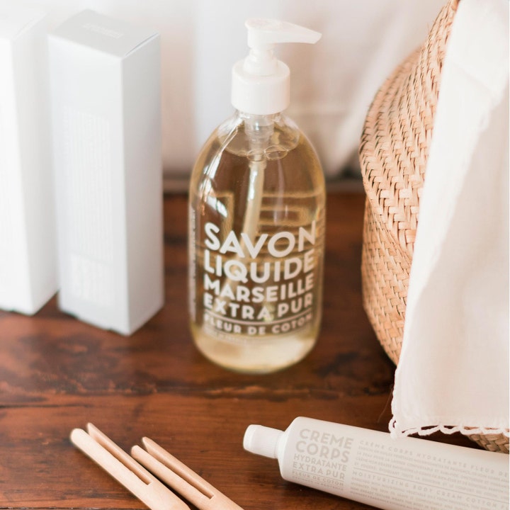 Compagnie de Provence Liquid Marseille Soap Cotton Flower 495 ml mild håndsåpe i klar pumpeflaske på et rustikt trebord