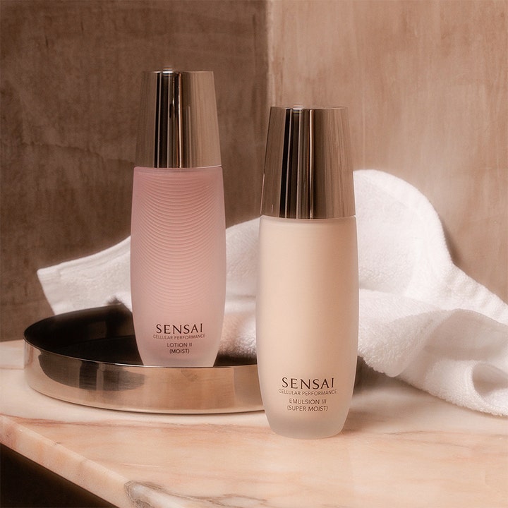 Sensai Cellular Performance Emulsion III 100 ml fuktighetskrem i hvit flaske ved siden av en håndduk