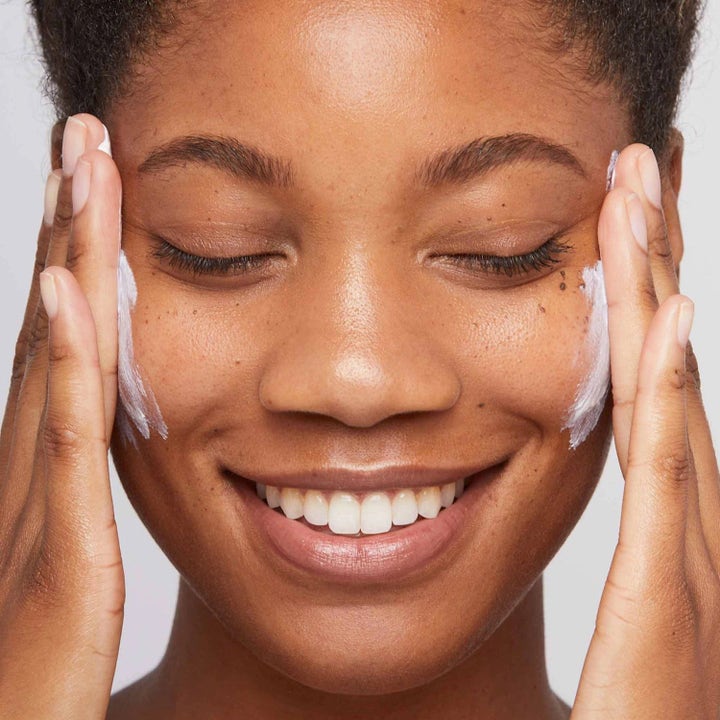 Dermalogica Invisible Physical Defense SPF30 Duo solkrem påført av en smilende kvinne med hvit krem på kinnene