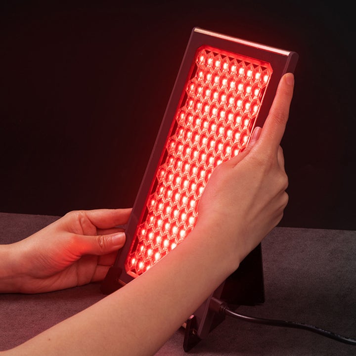 FAQ Swiss FAQ™ Led Panel 1 stk hudpleieverktøy for lysterapi som holdes av hender og lyser med et rødt bikubemønster