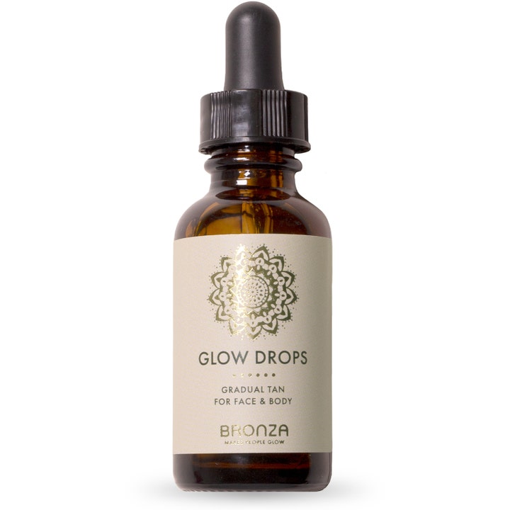 Bronza Glow Drops selvbruning som gir glød i en brun glassflaske med svart pipett og etikett med gullmønster