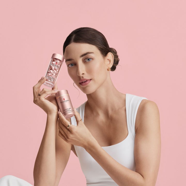 Elizabeth Arden Ceramide Retinol + Hpr Rapid Skin Renewing Eye Cream 15 ml øyekrem i rosa pumpeflaske vist av kvinne