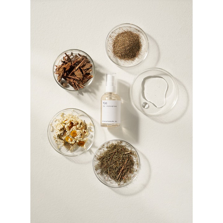 Mixsoon Calming Boosting Mist 50 ml beroligende ansiktsspray omgitt av naturlige planteingredienser i glasskåler.