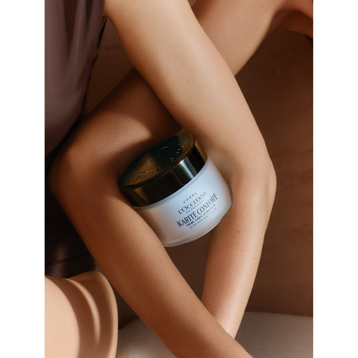 L'Occitane Shea Butter Ultra Rich Body Cream 200 ml fuktighetsgivende kroppskrem i frostet krukke holdt mot huden