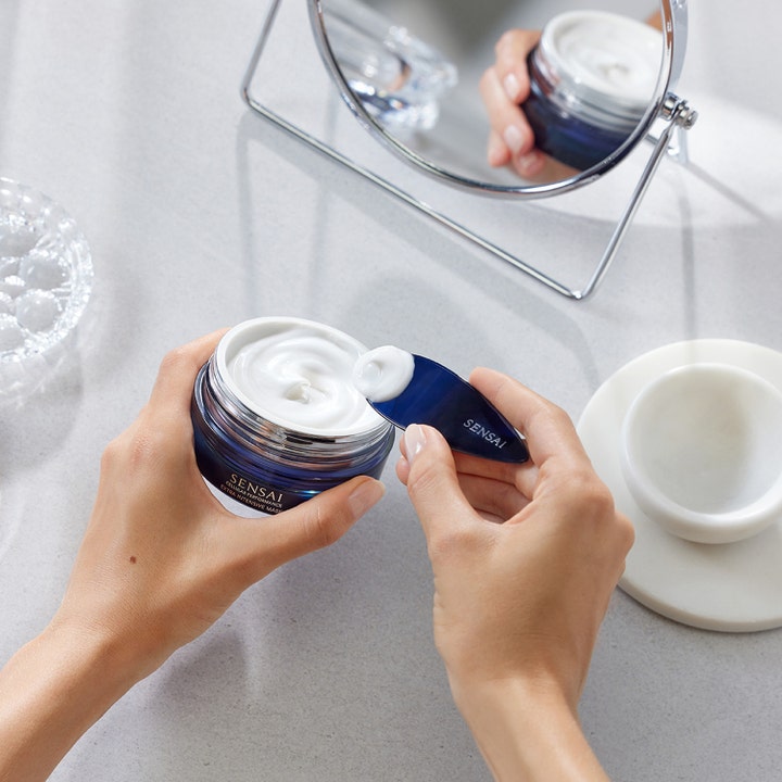 Sensai Cellular Performance Extra Intensive Mask 75 ml ansiktsmaske i blå krukke med hvit kremet konsistens på spatel