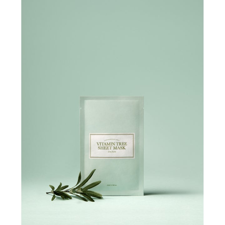 I'm from Vitamin Tree Sheet Mask 1 stk glødgivende ansiktsmaske i lysegrønn pose ved siden av en liten grønn kvist