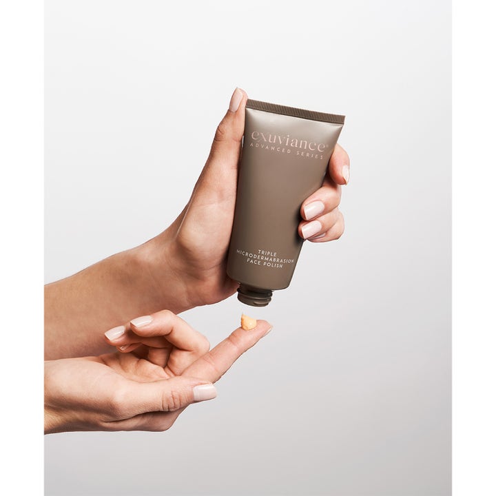 Exuviance Triple Microdermabrasion Face Polish 75 g ansiktsskrubb som gir glød med ferskenfarget krem på en fingertupp