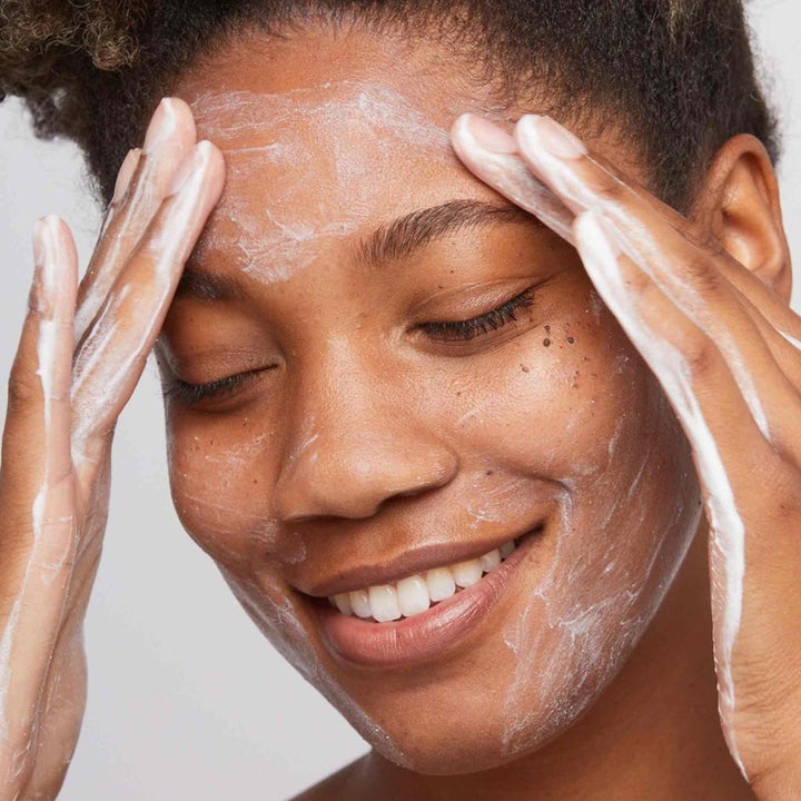 Dermalogica Daily Microfoliant Duo 148 g ansiktspeeling som gir glød vist på kvinne som masserer skum i ansiktet.