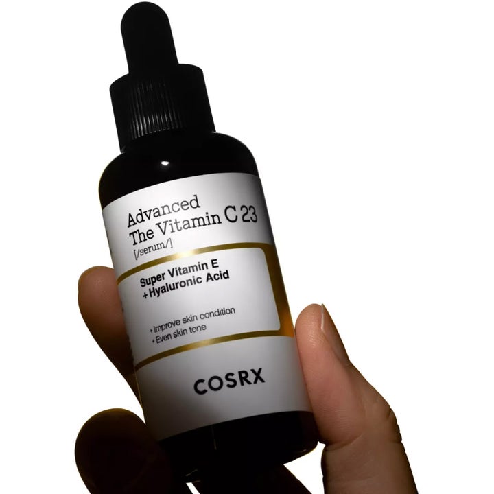 COSRX Advanced The Vitamin C 23 Serum 20 g glødgivende serum i mørk glassflaske med pipette holdt i en hånd