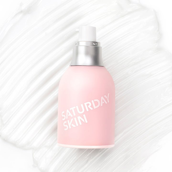 Saturday Skin Wide Awake Brightening Eye Cream 30 ml opplysende øyekrem i rosa flaske på hvit kremtekstur