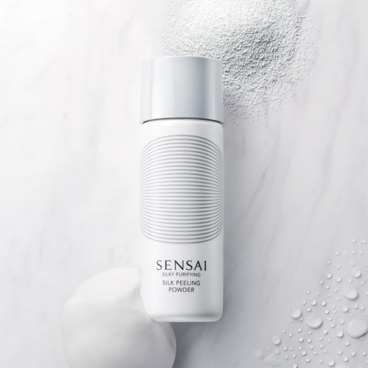 Sensai Silky Purifying Silk Peeling Powder 40 g eksfolierende ansiktsskrubb med synlig pudder og skum på marmor
