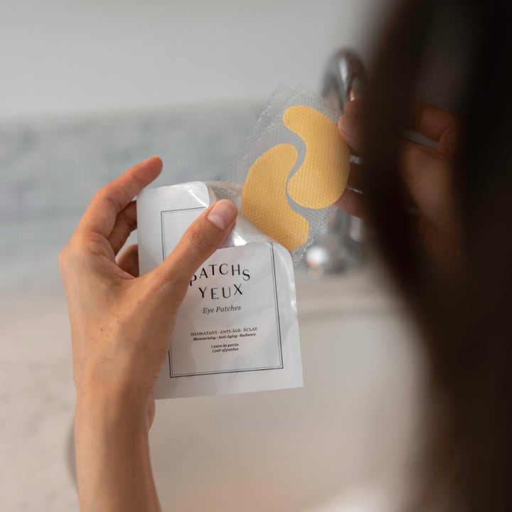 Codage Paris The Eye Contour patches 1 sett øyemasker gir fuktighet og glød idet to gylne patches tas ut av hvit pose.