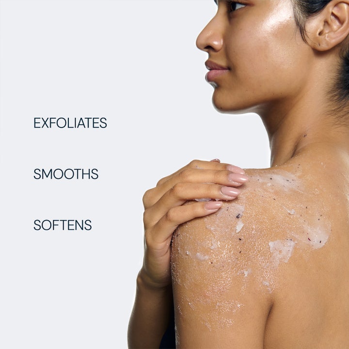 Elemis Frangipani Monoi Salt Glow 490 g eksfolierende kroppsskubb på hud med tekst: Exfoliates, Smooths, Softens.