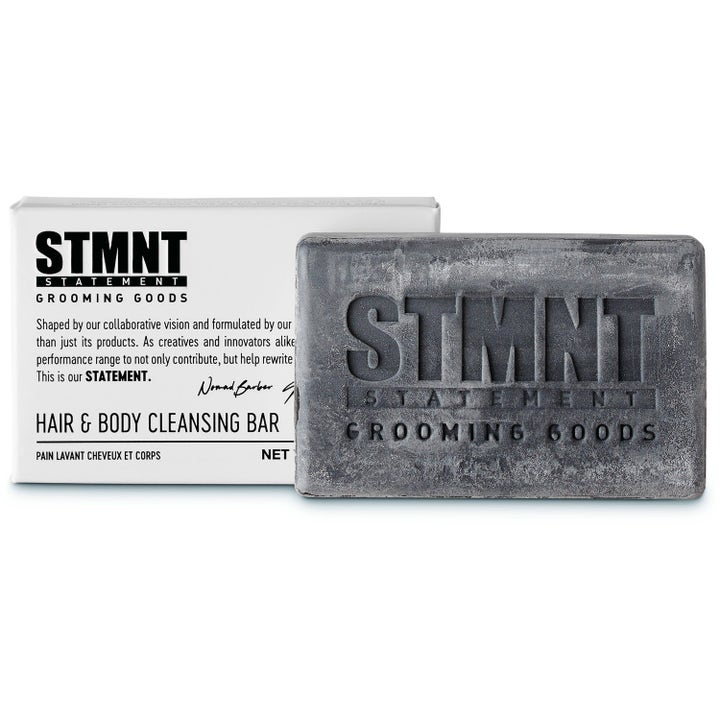 STMNT Hair & Body Cleansing Bar rensende såpestykke for hår og kropp i mørkegrå farge med preget logo og hvit eske