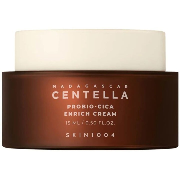 Skin1004 Madagascar Centella Probio-Cica Enrich Cream 15 ml styrkende ansiktskrem i mørkebrun krukke med beige lokk.