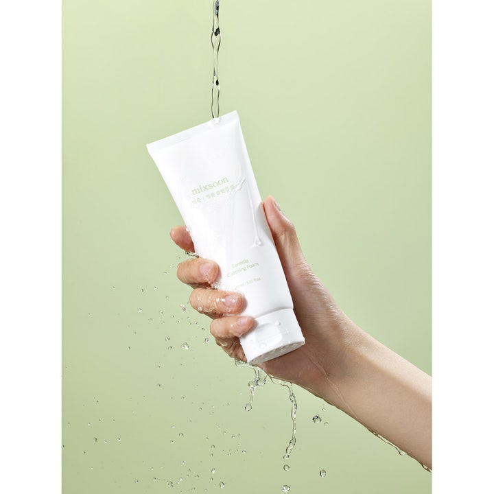 Mixsoon Centella Cleansing Foam 150 ml rengjøringsskum i hvit tube som holdes i en hånd under rennende vann