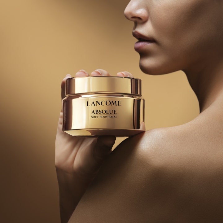 Lancôme Absolue Soft Body Balm 200 ml nærende kroppskrem i eksklusiv gullkrukke holdt av en kvinne mot skulderen