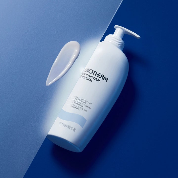 Biotherm Lait Corporel 400 ml fuktighetsgivende bodylotion i hvit pumpeflaske med hvit kremet tekstur på blå bakgrunn