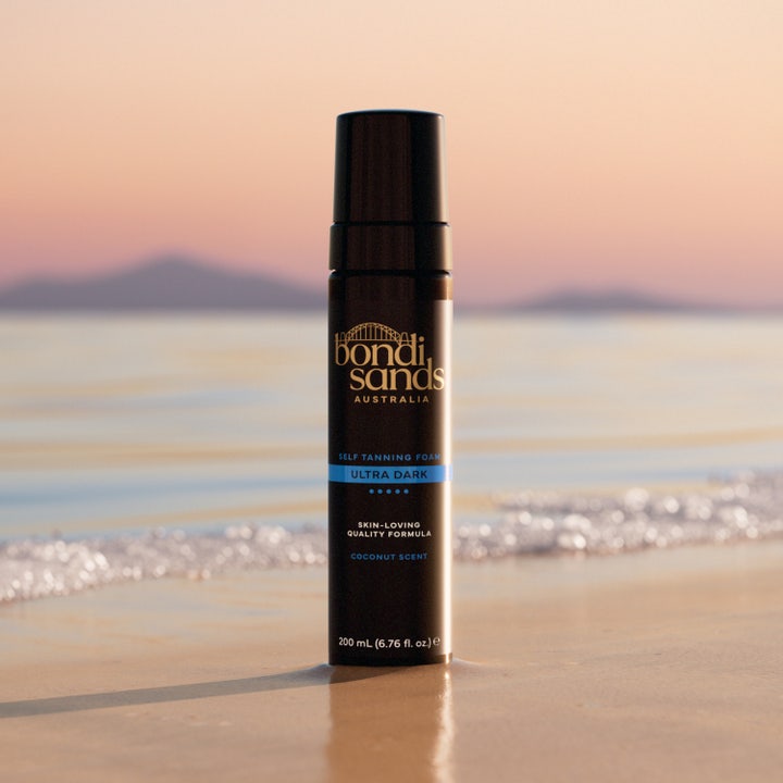 Bondi Sands Self Tanning Foam Ultra Dark 200 ml selvbruning for kropp i svart flaske på en strand ved havet