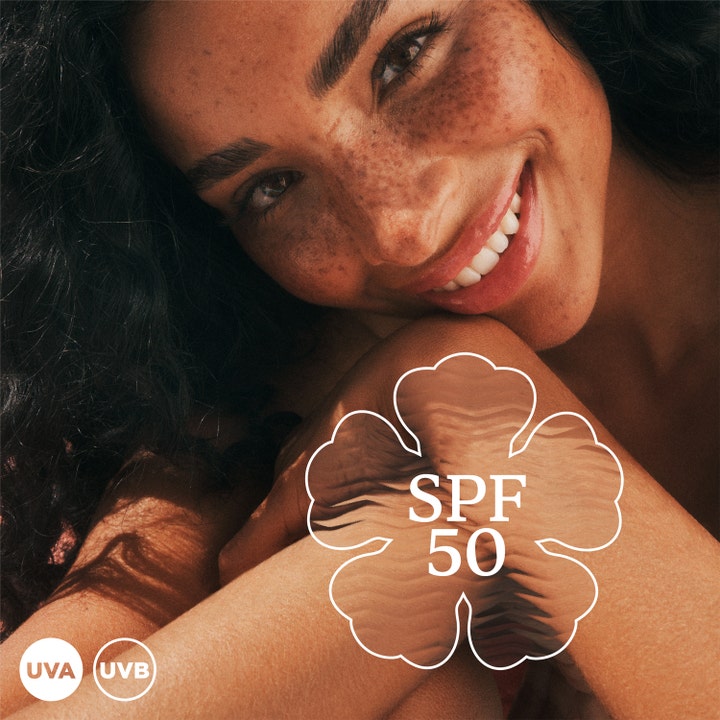 Hawaiian Tropic Glowing Protection Face Lotion 50 ml solkrem ansikt gir glød på kvinne med SPF 50 og UVA UVB symboler.