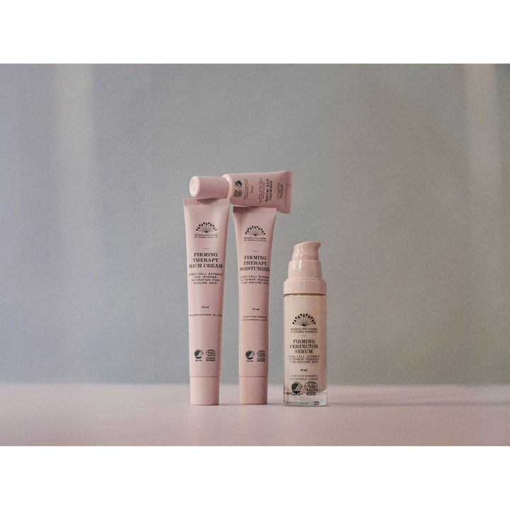 Rudolph Care Firming Therapy Rich Cream 50 ml oppstrammende dagkrem i rosa tube vist i en gruppe hudpleieprodukter