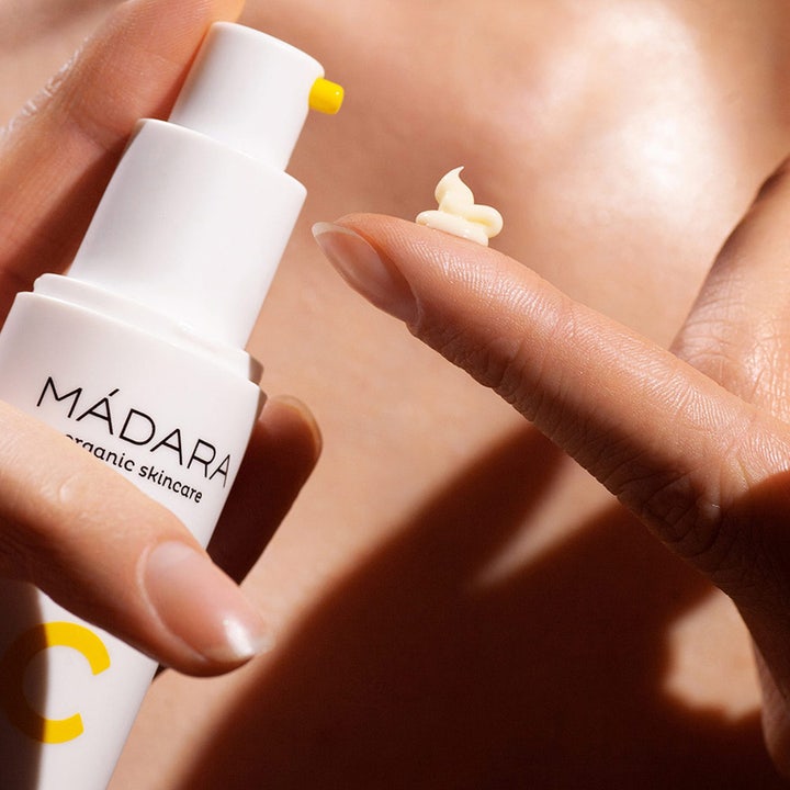 MÁDARA Vitamin C Illuminating Recovery Cream 50 ml glødgivende ansiktskrem med kremet tekstur på en fingertupp