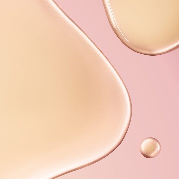 Nuxe Huile Prodigieuse Florale Roll-On 60 ml kroppsolje gir glød med flytende gylne dråper på rosa bakgrunn