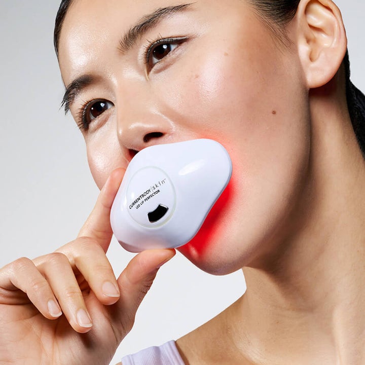 Currentbody Skin LED Lip Perfector hvit LED-enhet for lepper som gir fyldigere hud brukt av en kvinne