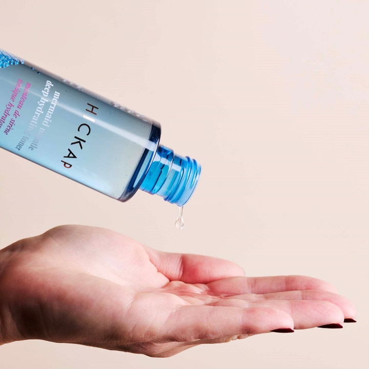 Hickap Mermaid Mantle Deep Hydrating Toner 150 ml fuktighetsgivende ansiktsvann drypper fra blå flaske ned i en åpen hånd