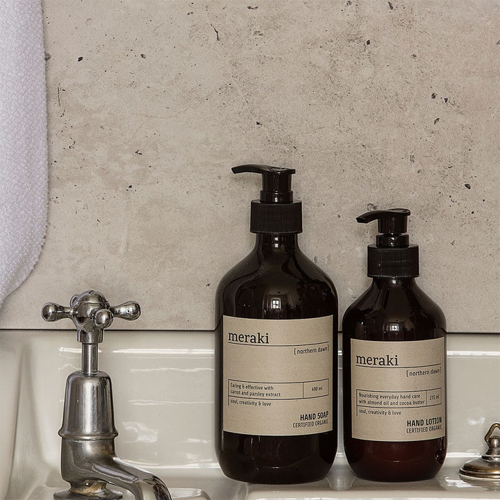 Meraki Northern Dawn Hand Soap 490 ml pleiende økologisk håndsåpe i mørk pumpeflaske på en hvit vask.
