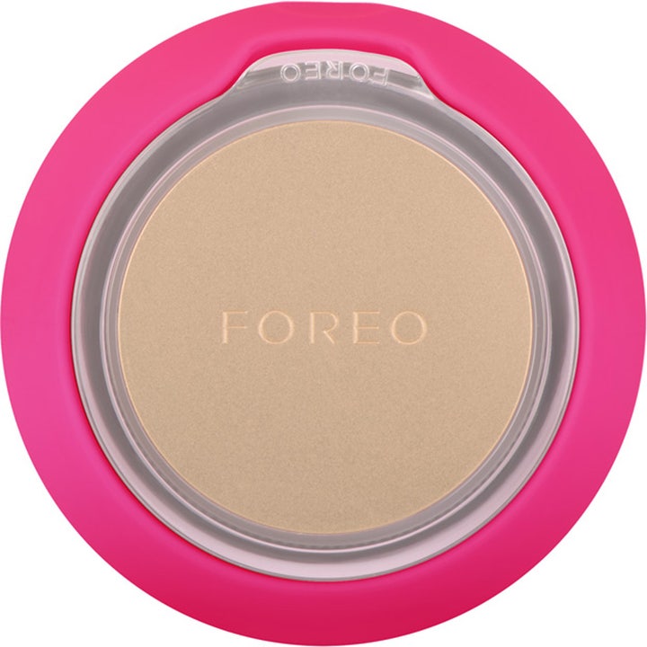 FOREO UFO mini 2 Fuchsia beauty tech som gir glød med rund gullplate og rosa silikon på baksiden