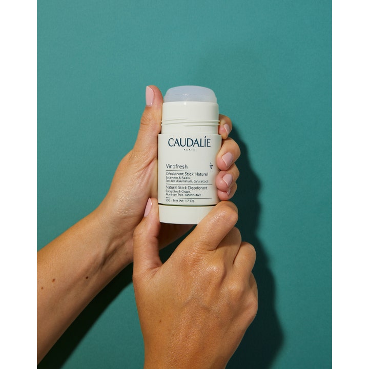 Caudalie Vinofresh Stick Deodorant 50 ml aluminiumsfri og alkoholfri deodorant i hylse som holdes mot grønn bakgrunn.