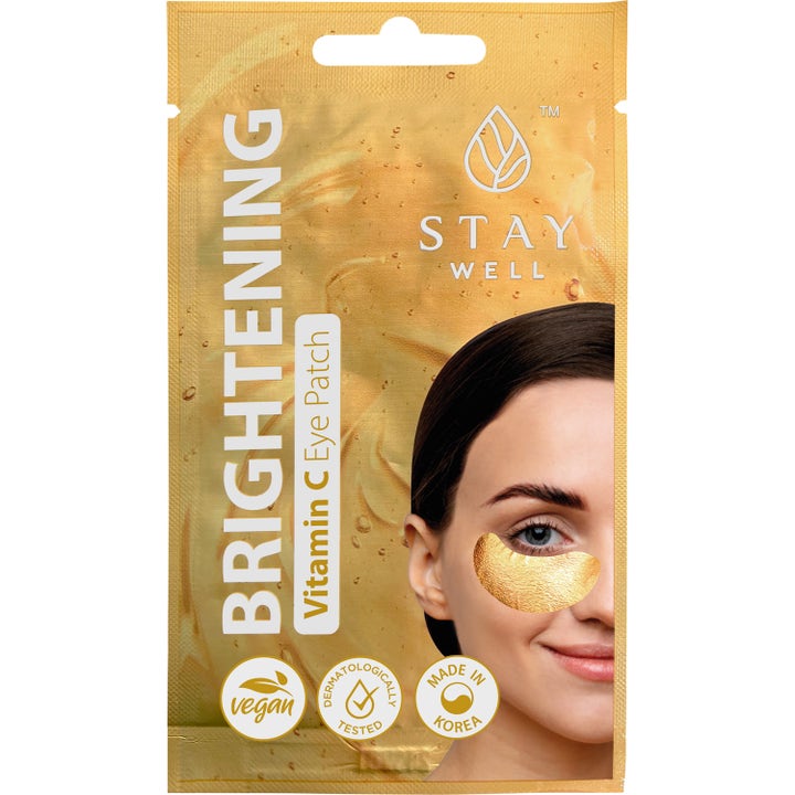 Stay Well Brightening Vitamin C Eye Patch gir glød i gullfarget pose med bilde av kvinne med gullskimrende øyelapp