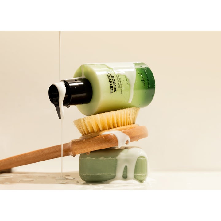 haruharu wonder Black Bamboo Daily Smoothing Body Oil 200 ml flytende olje som renner over flaske og trebørste