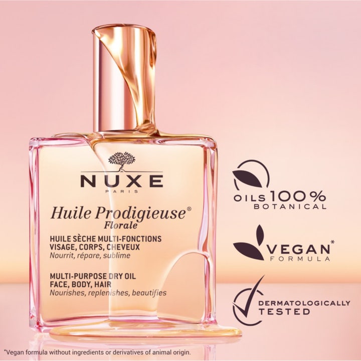 Nuxe Huile Prodigieuse Florale 100 ml nærende tørrolje i en rosa glassflaske som står på skrå mot en rosa bakgrunn