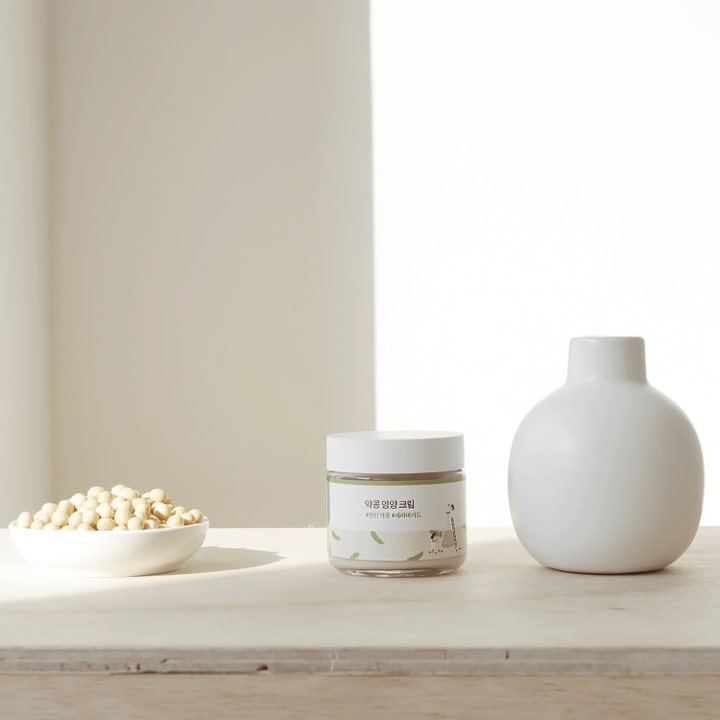 Round Lab Soybean Nourishing Cream 80 ml nærende ansiktskrem i krukke plassert ved soyabønner og en hvit vase