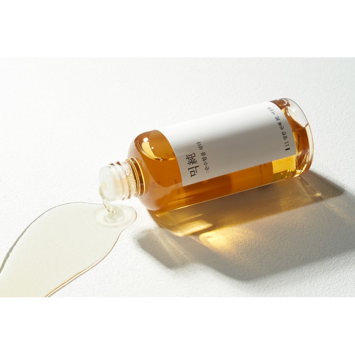 Mixsoon Heartleaf Essence 100 ml beroligende essence med gyllen flytende tekstur som renner ut av flasken.