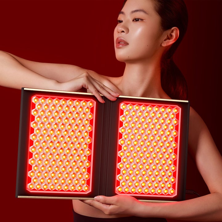 FAQ Swiss FAQ™ Dual Led Panel 1 stk hudpleieverktøy kvinne som holder et sammenleggbart panel med rødt LED-lys