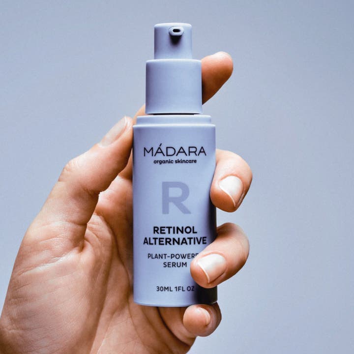 MÁDARA Retinol Alternative Serum 30 ml i lilla pumpeflaske holdt i en hånd motvirker rynker og gir elastisitet.