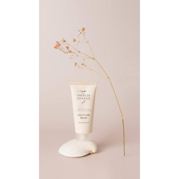Care by Therese Johaug Multi Use Balm 30 ml beskyttende krem for kaldt vær i hvit tube på et dekorativt skjell
