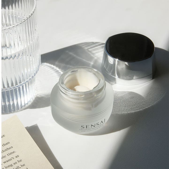 Sensai Cellular Performance Eye Contour Cream 15 ml anti-aging øyekrem i frostet glasskrukke med hvit kremet tekstur.