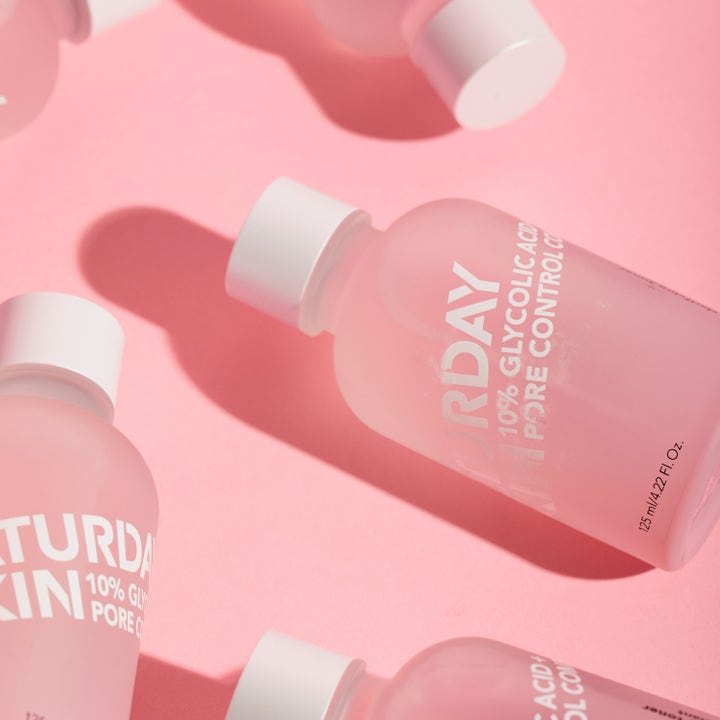 Saturday Skin Pore Clarifying Toner 125 ml eksfolierende toner i frostet glassflaske med 10% glykolsyre på rosa bakgrunn.